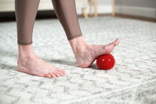 Load image into Gallery viewer, Soft-Spike Massage Ball in use - red