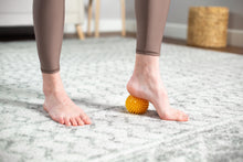 Load image into Gallery viewer, Soft-Spike Massage Ball in use - yellow