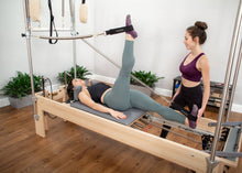 Load image into Gallery viewer, Woman using the reformer trapeze combination | caption::Shown in Storm Upholstery