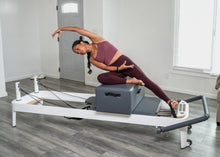 Load image into Gallery viewer, Female Pilates professional exercising on an Allegro 2 reformer with box accessory