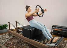 Load image into Gallery viewer, Woman using large sitting box on reformer with Ultra-Fit Circle.