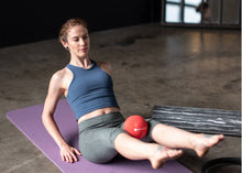 Load image into Gallery viewer, Woman stretching with a playground ball between legs on a purple mat.