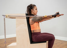 Load image into Gallery viewer, Pilates profession exercising on a Pilates arm chair
