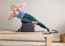 Load image into Gallery viewer, padded footstrap for reformer exercises in use | caption::Short Footstrap on Clinical Reformer
