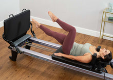 Load image into Gallery viewer, woman exercising on padded jumpboard, installed on Allegro Reformer
