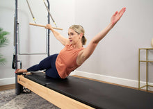 Load image into Gallery viewer, Pilates professional exercises on Rialto Reformer with tower
