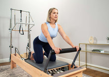 Load image into Gallery viewer, Woman exercising on Studio Reformer with tower
