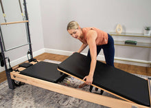 Load image into Gallery viewer, Pilates professional using mat conversion kit on Rialto Reformer
