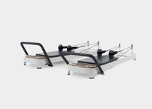 Load image into Gallery viewer, A photo of the Allegro 2 Pilates Reformer showing both the carbon fiber footbar and the steel footbar options. | caption::Carbon Fiber Footbar, Steel Footbar
