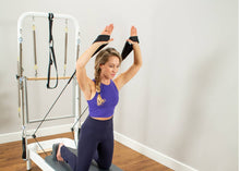 Load image into Gallery viewer, Woman exercising on Allegro 2 Reformer Tower of Power, focusing on full-body movements.
