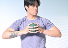 Load image into Gallery viewer, Man gripping green inflatable small exercise ball.

