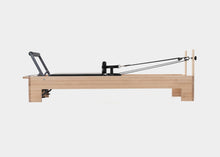 Load image into Gallery viewer, Side view of a Pilates studio reformer.
