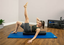 Load image into Gallery viewer, Woman pressing low back into extra-firm foam roller, engaging core.
