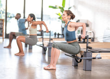 Load image into Gallery viewer, Students exercising their back on a Rialto Reformer Plank Bar.
