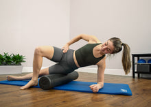 Load image into Gallery viewer, Woman using an extra-firm foam roller for back and hip exercises.
