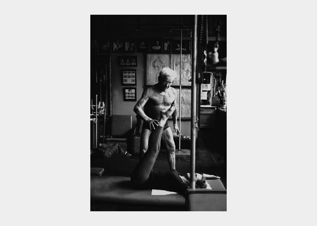 Classic photograph of Joseph Pilates instructing a Pilates session | caption::Client and Mat