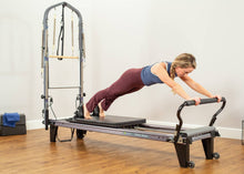 Load image into Gallery viewer, Woman working out with the Allegro Reformer Tower of Power and standing platform
